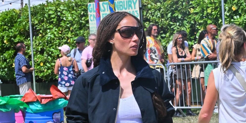 British model Adwoa Aboah was seen wearing black Miu Miu MU A01S 1AB01T shield sunglasses at the Glastonbury Festival 2025. Shop online now on Pretavoir
