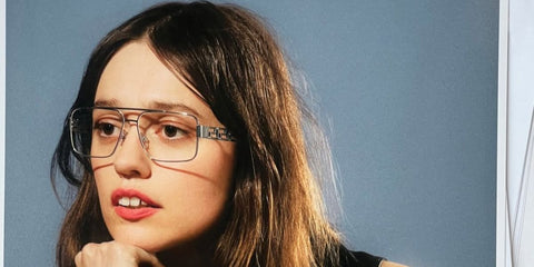 Aimee Lou Wood was seen wearing gunmetal Versace 1308 1000 optical glasses in the Versace Greca Eyewear campaign, October 2025.