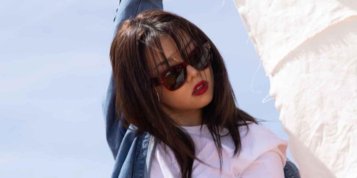 Singer, rapper, and dancer Bailey Sok was seen wearing transparent red Ray-Ban Mega Wayfarer RB 0840S 6679/B1 sunglasses in a Ray-Ban campaign, August 2023.