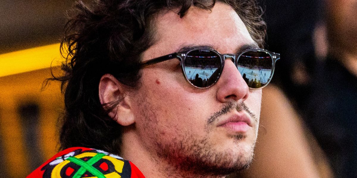 Off Campus star Belmont Cameli wore black Oliver Peoples Riley Sun OV5004SU 1005/P1 round sunglasses with green g-15 Polarised lenses during the ice hockey hame between Chicago Blackhawks against the St. Louis Blues in October 2026