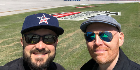 Bill Burr, pictured on the right with fellow comedian Nate Bargatze, was seen wearing gold Ray-Ban Aviator 3025 112/17 Blue Flash Mirror sunglasses at an NASCAR event, shared on Nate Bargatze's Twitter / X post. Shop online now on Pretavoir