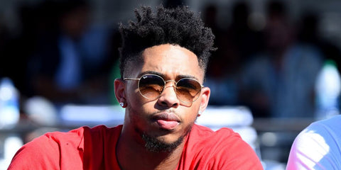 Basketball player Brandon Ingram was seen wearing Ray-Ban Round Metal RB 3447 001/51 sunglasses with brown to clear gradient lenses in an interview with USA Today