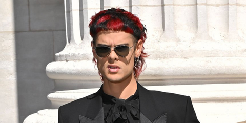 Argentine singer Ca7riel was seen wearing silver Saint Laurent Sun SL 831 Vesper 002 sunglasses at the Saint Laurent Menswear Spring/Summer 2026 fashion show during Paris Men's Fashion Week.