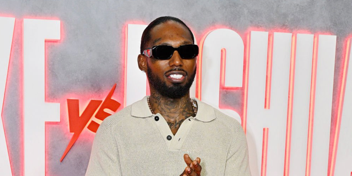 Rapper Castillo was seen wearing black Prada PR 17WS 1AB5S0 Symbole Sunglasses at the Jake Paul vs Anthony Joshua Netflix Live Event in Miami, December 2025.