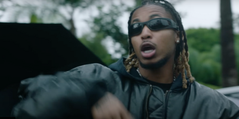 DDG was seen wearing black Balenciaga BB0290S 001 Reverse Xpander 2.0 wraparound sunglasses in his 2023 music video She Don't Play