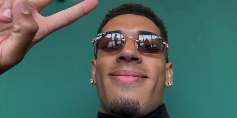 Spanish footballer Dani Castilla was seen wearing gold Miu Miu MU B50S 5AK20I rimless square sunglasses with purple brown lenses at Madrid Open Tennis Championships 2026.