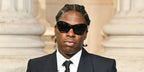 Canadian singer Daniel Caesar was seen wearing black Prada PR A27S 16K5S0 sunglasses at the Saint Laurent Menswear Fall/Winter 2025 fashion show during Paris Men's Fashion Week