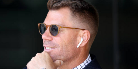 Australian cricketer David Warner was seen wearing brown Oliver Peoples Riley Sun OV5004SU 1699/56 round sunglasses with blue lenses during a Men's 1st Test Match between Australia and India in Perth, November 2024.