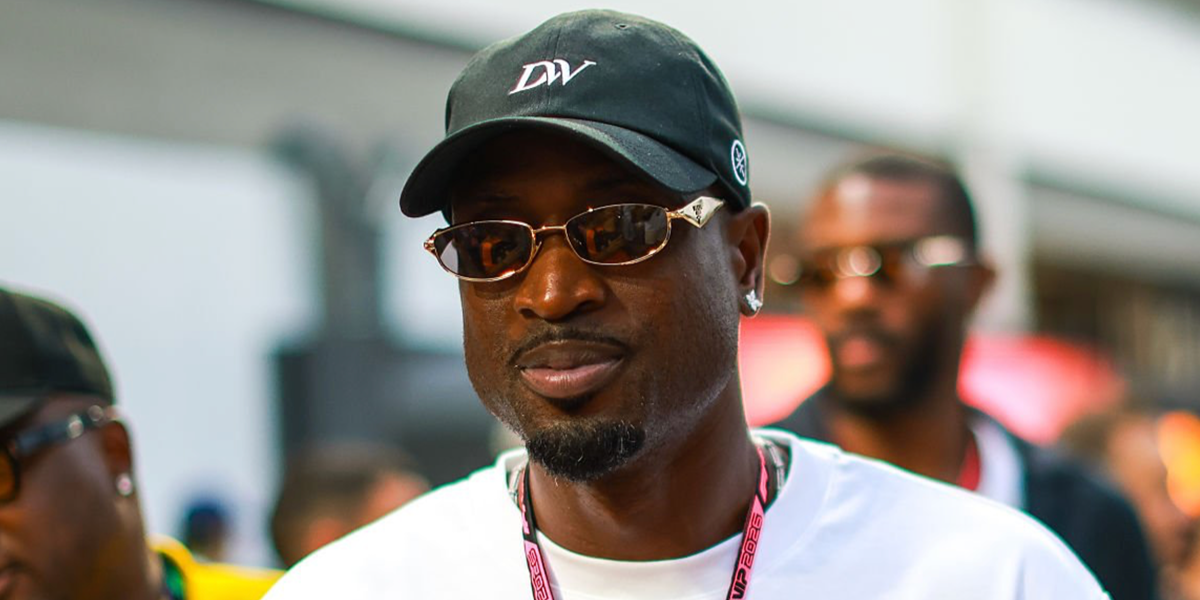 Dwyane Wade wore gold Prada PR D51S 5AK20I sunglasses with purple brown lenses at the F1 Singapore Grand Prix, October 2026.