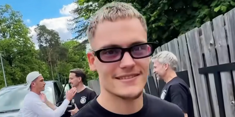German footballer Florian Wirtz was seen wearing black Prada PR B06S 16K40J sunglasses with light purple lenses as he arrived at the German team training camp in May 2025.