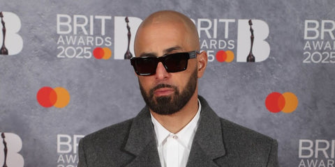 Palestian-American music producer Ghazi "GHAZI" Shami was seen wearing black Prada PR 25ZS 1AB05Z Polarised square sunglasses with dark red pink lenses to attend the 2025 Brit Awards in London