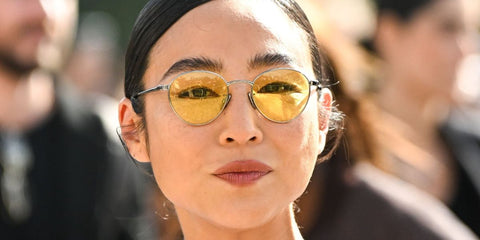 Greta Lee was seen wearing ruthenium Loewe Slim LW40152U 14J round sunglasses with yellow lenses at Loewe Spring/Summer 2025 fashion show during Paris Fashion Week