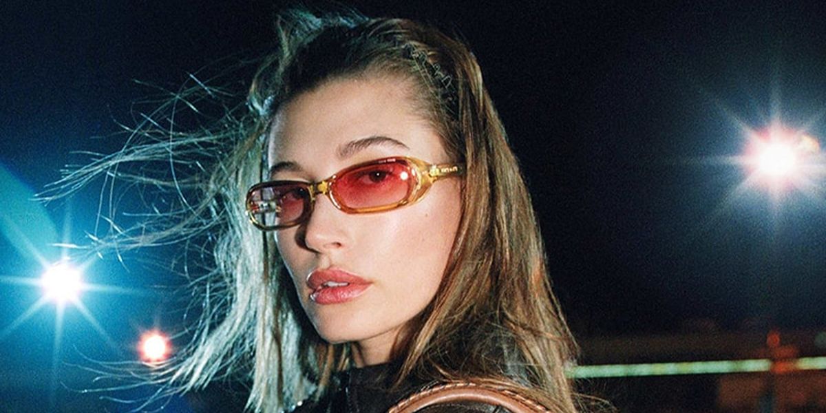 Hailey Bieber wore transparent yellow Miu Miu MU C07SU 24S81E sunglasses with pink gradient lenses in the Miu Miu Fall Winter 2026 campaign.