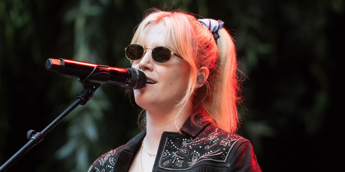 Hannah Reid, lead vocalist of London Grammar, was seen wearing gold Prada PR B53S 5AK09Z oval sunglasses with havana temple on stage at Principality Stadium in Cardiff, Wales, July 2025. Shop online now on Pretavoir