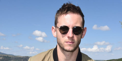JBritish actor Jamie Bell was seen wearing black and gold Garrett Leight Wilson 4003 MBK-MST/PGY round sunglasses at the Telluride Film Festival