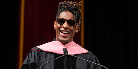 Jon Batiste was seen wearing black and gold David Beckham DB 1098/S 2M2IR sunglasses during his keynote speech at the 2023 Loyola University New Orleans Commencement Ceremony