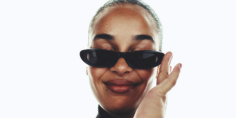 Jorja Smith was seen wearing black Saint Laurent Sun SL 557 Shade 001 thin sunglasses in a fashion editorial page of Porter