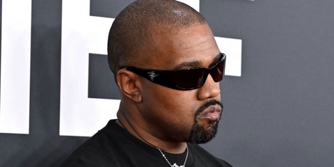 Kanye West (Ye) wears Prada PR A14S 1AB5S0 black wraparound sunglasses at the 67th Grammy Awards 2025.