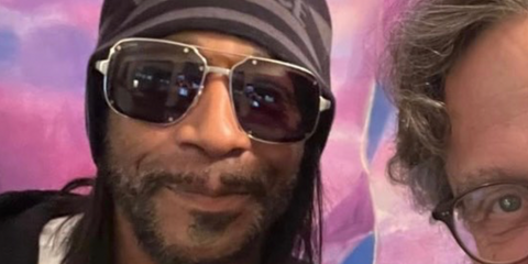 Comedian Katt Williams is seen wearing studded Cartier CT0194S 001 silver aviator sunglasses while being photographed with a fan