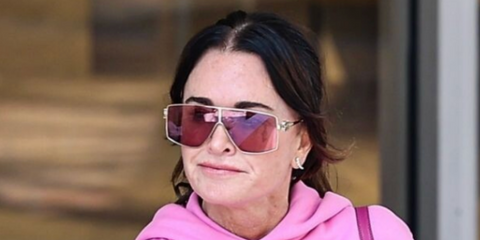 Kyle Richards wearing mask style Miu Miu sunglasses with pink lenses