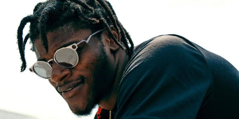 Lamar Jackson is seen wearing Oakley Deadbolt OO6046 01 Prizm sunglasses in an editorial page of Sports Illustrated