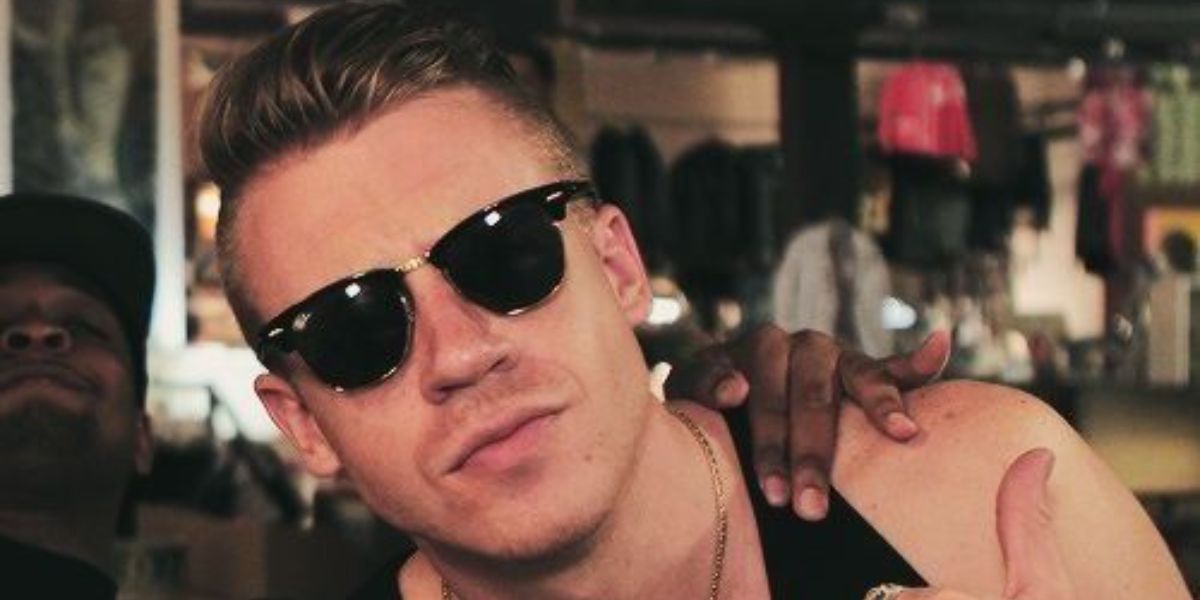 Macklemore was seen wearing the iconic Ray-Ban Clubmaster 3016 W0365 Black half-rim sunglasses