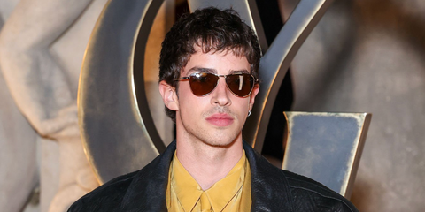 Spanish actor Manu Rios was seen wearing gold Saint Laurent Sun SL 831 Vesper 005 sunglasses with brown lenses at the Saint Laurent Fall/Winter 2026 fashion show during Paris Fashion Week.