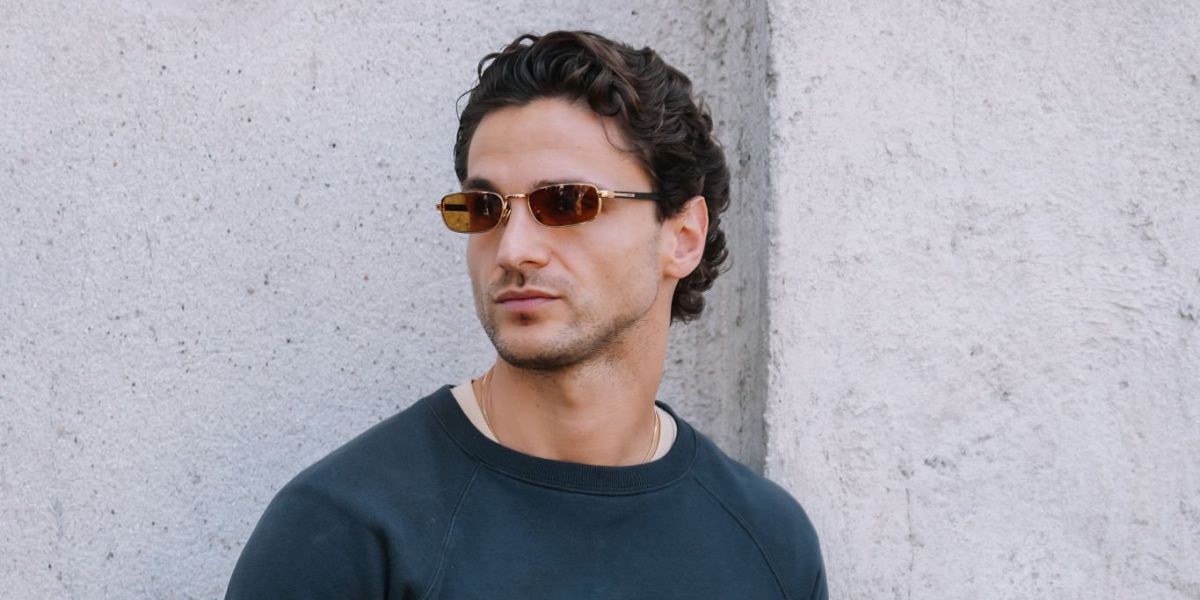 Swiss model Mergim Shabani was seen wearing gold Prada PR B54S 5AK50P sunglasses with brown lenses at the Prada Menswear Spring/Summer 202 fashion show during Milan Men's Fashion Week.
