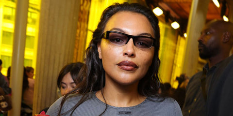 Model Paloma Elsesser was seen wearing black Miu Miu MU B07S 16K04O half-rim sunglasses with grey gradient lenses at the Miu Miu Spring/Summer 2026 fashion show during Paris Fashion Week. Shop online now on Pretavoir