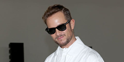 Italian writer and creative force Paolo Stella was seen wearing the iconic Ray-Ban Wayfarer 2140 901 Black sunglasses at the MaxMara Spring/Summer 2026 fashion show during Milan Fashion Week.