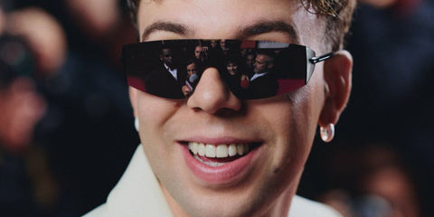 Spanish singer Quevedo was seen wearing black Bottega Veneta BV1299S 001 shield sunglasses in his new album "Buenas Noches" promotional image, shared through his Instagram post in November 2024.