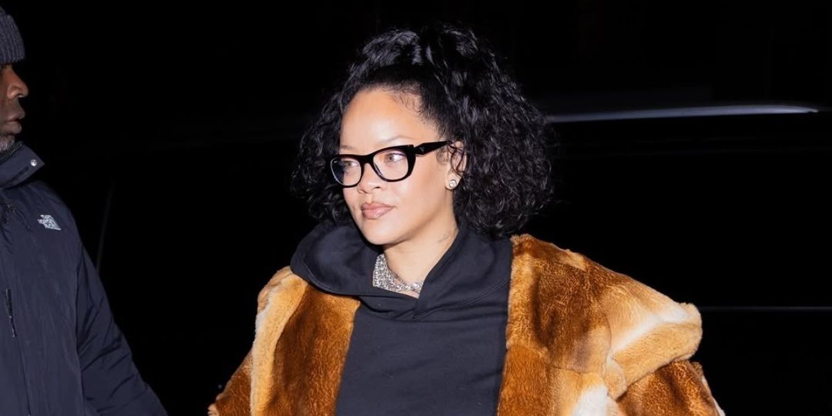 Rihanna wearing Prada PR A18V 16K1O1 Black Glasses and an oversize hoodie and fur coat