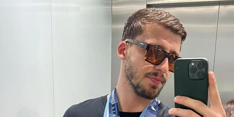 Portuguese footballer Ruben Dias was seen wearing tortoiseshell Prada PR 19WS 2AU8C1 sunglasses with dark brown lenses in his mirror selfie. Shop online now on Pretavoir
