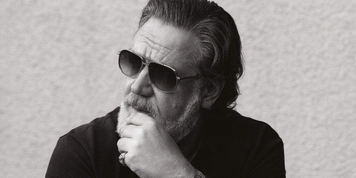 Russell Crowe was seen wearing Cutler and Gross Sun Sloane 1423 03 Silver Gold sunglasses with green gradient lenses in a The Rake feature, January 2026.