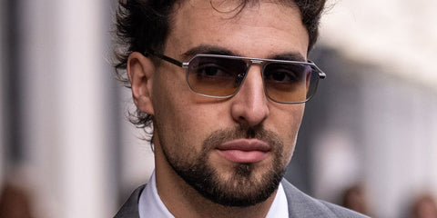 Palestinian rapper Saint Levant was seen wearing matte silver Prada PR A53S 27506Z sunglasses with blue to yellow lenses at the Prada Menswear Fall/Winter 2026 fashion show during Milan Men's Fashion Week.