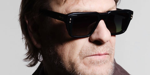 Sean Bean was seen wearing black Akoni Hercules AKS 105D sunglasses with grey to green gradient lenses in a Hunger Magazine feature, November 2025.