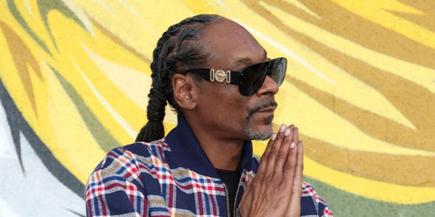 Snoop Dogg was seen wearing black Versace 4391 GB1/87 sunglasses at  the 12th Annual TDE Christmas Concert and Toy Drive in Los Angeles, December 2025.