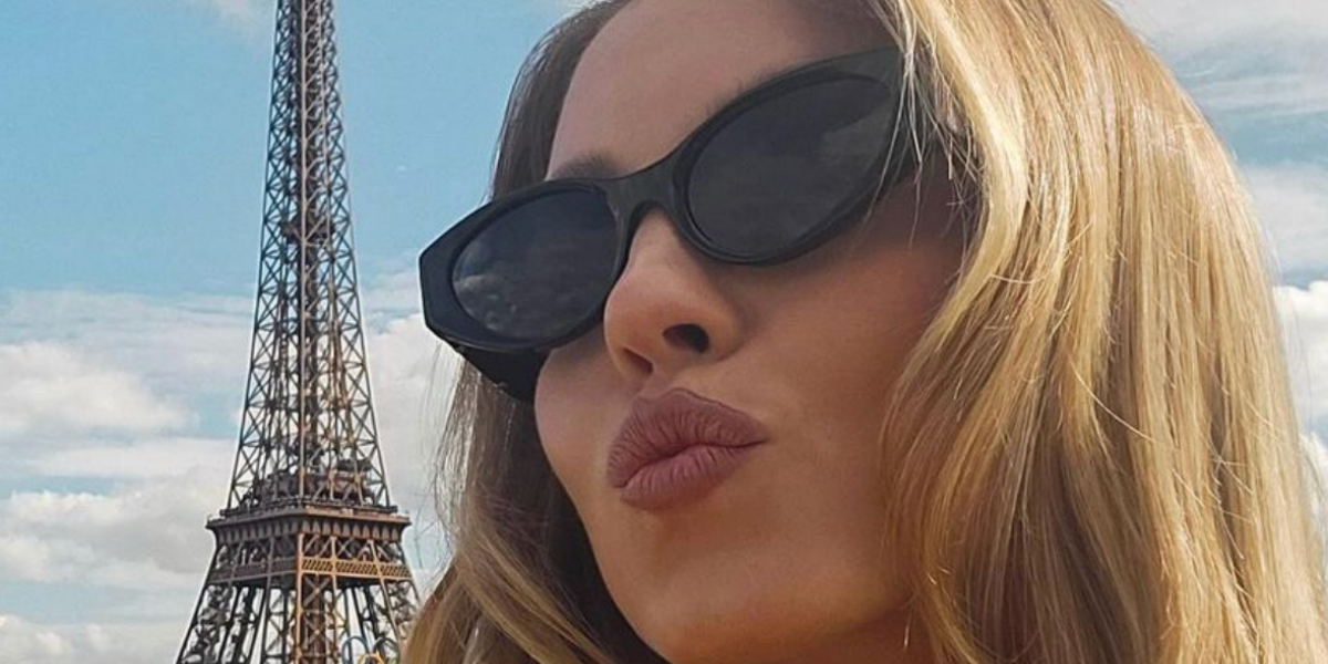 Sydney Sweeney poses next to Eiffel Tower wearing Versace 4470B GB1/87 Sunglasses.