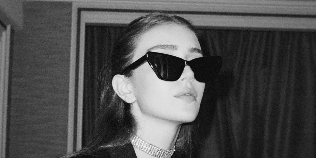 Talia Ryder was seen wearing black Saint Laurent Sun SL 214 Kate 001 cat eye sunglasses to the Saint Laurent Spring/Summer 2022 fashion show during Paris Fashion Week