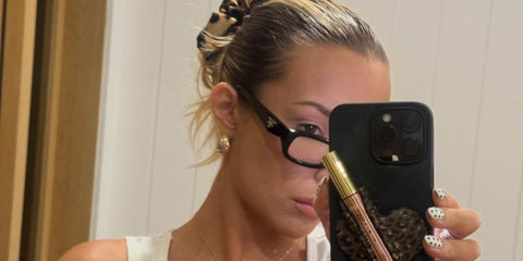 Celebrity and internet personality Tana Mongeau was seen wearing black Prada PR B06S 16K08N Blue Control optical glasses in her Instagram post, December 2025.