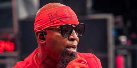 Rapper Tech N9ne was seen wearing black Gucci GG0034SN 002 sunglasses with glittered green and red temples onstage at the Sublime Festival in Portland, Oregon, July 2026.