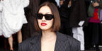 Tiffany Hsu of MyTheresa was seen wearing black Prada PR 08YS 1AB5S0 Symbole butterfly Sunglasses at the Prada Fall/Winter 2023 fashion show during Milan Fashion Week