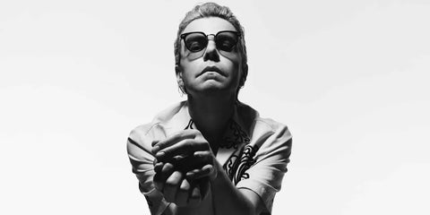 Tim Burgess was seen wearing black Prada PR 17YS 1AB03R Polarised sunglasses in a Hunger Magazine feature, July 2022.