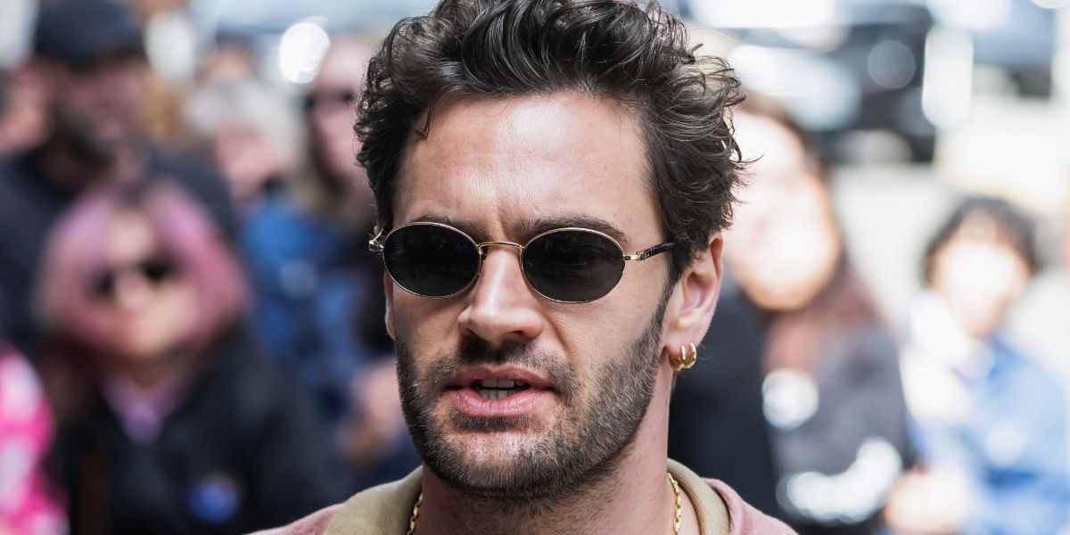 Actor Tom Bateman was seen wearing gold and black Persol Ida 1018S 515/58 Polarised oval sunglasses at the Toronto International Film Festival 2025. Shop online now on Pretavoir