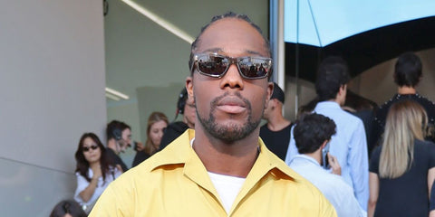 Actor Tosin Cole was seen wearing transparent tera Prada PR B11S 18T70F sunglasses with brown lenses at the Prada Menswear Spring/Summer 2026 fashion show during Milan Fashion Week.