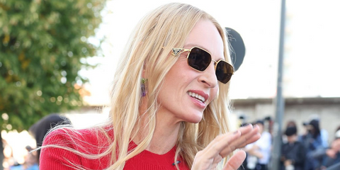 Uma Thurman was seen wearing gold Prada PR A51S 15N01T sunglasses with brown lenses at the Prada Spring/Summer 2027 fashion show during Milan Fashion Week.
