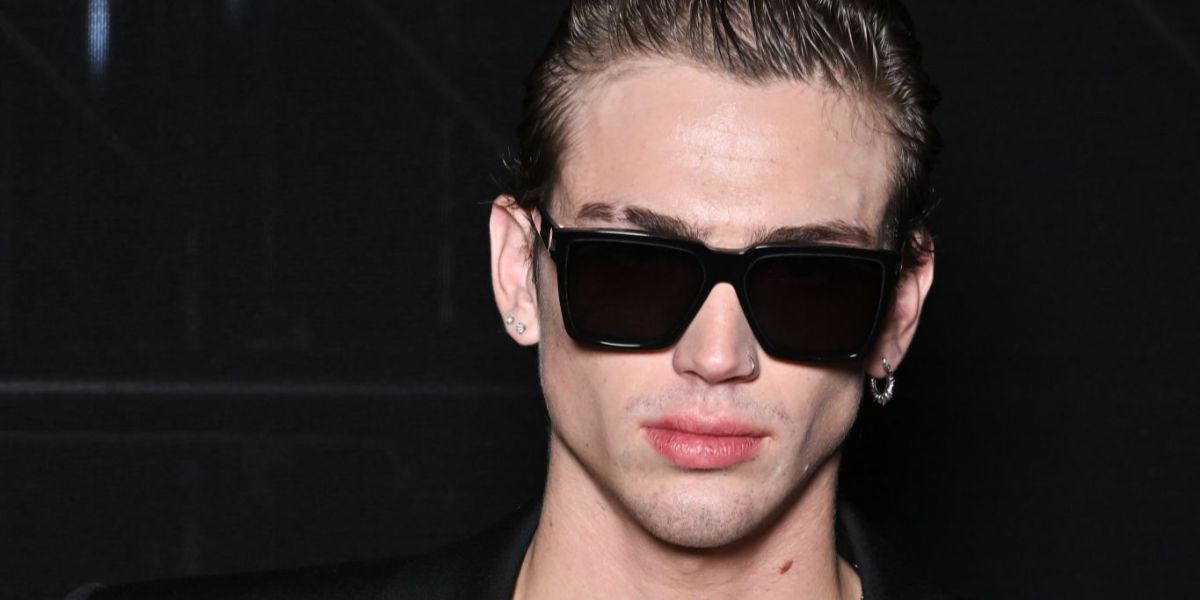 Model and content creator Vinnie Hacker was seen wearing black Saint Laurent Sun SL 610 001 square sunglasses at the Saint Laurent Spring/Summer 2024 fashion show during Paris Fashion Week.